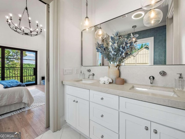 bathroom featuring ornamental molding, wood-type flooring, tasteful backsplash, and dual bowl vanity