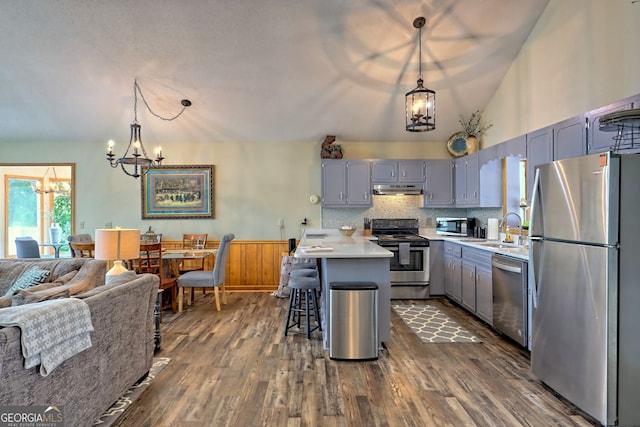 kitchen with appliances with stainless steel finishes, an inviting chandelier, and pendant lighting