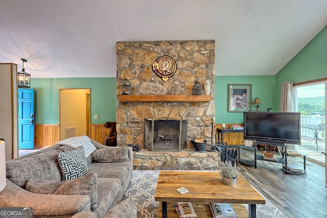 living room with a fireplace, vaulted ceiling, hardwood / wood-style floors, and a chandelier