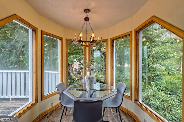 sunroom featuring a notable chandelier and plenty of natural light