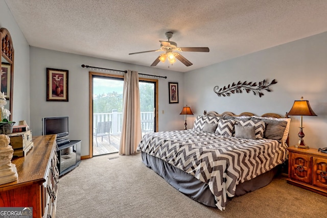 carpeted bedroom featuring ceiling fan, access to outside, and a textured ceiling