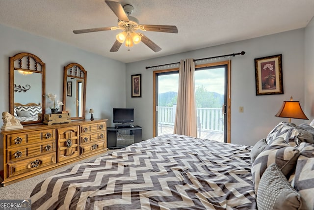 bedroom featuring ceiling fan, carpet flooring, access to exterior, and a textured ceiling