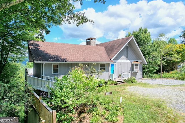 view of front of property with a deck and a front lawn