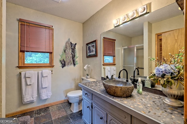 bathroom featuring toilet, a textured ceiling, an enclosed shower, and vanity