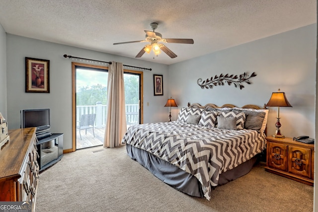 carpeted bedroom featuring ceiling fan, access to exterior, and a textured ceiling