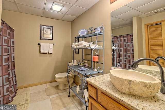 bathroom with tile patterned floors, vanity, a paneled ceiling, and toilet