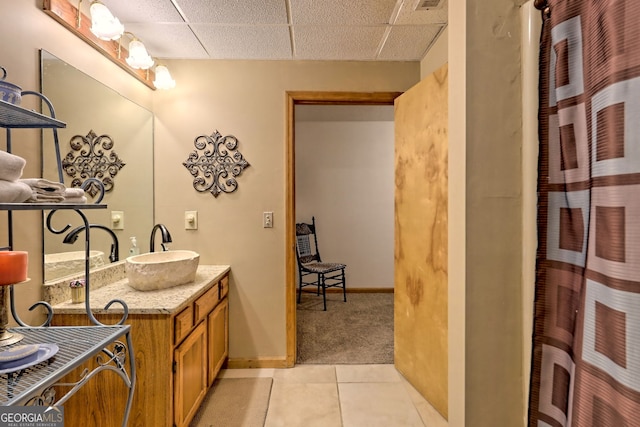 bathroom featuring a paneled ceiling, vanity, and tile patterned flooring