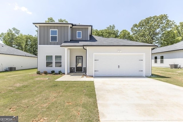 view of front of home with a garage, a front lawn, and central AC unit