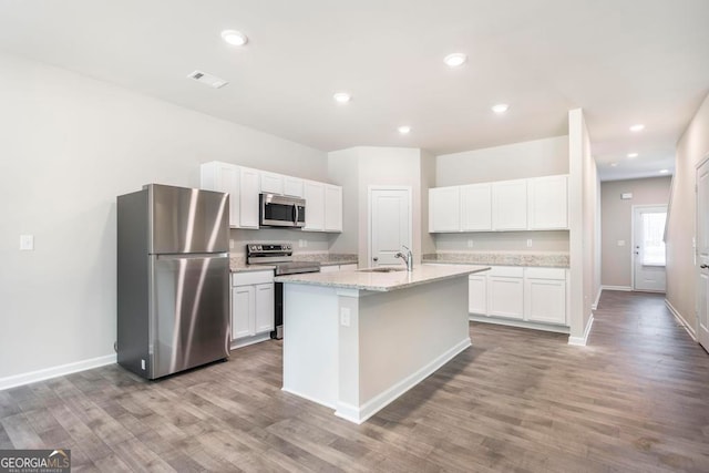 kitchen featuring a kitchen island with sink, hardwood / wood-style flooring, stainless steel appliances, and white cabinets