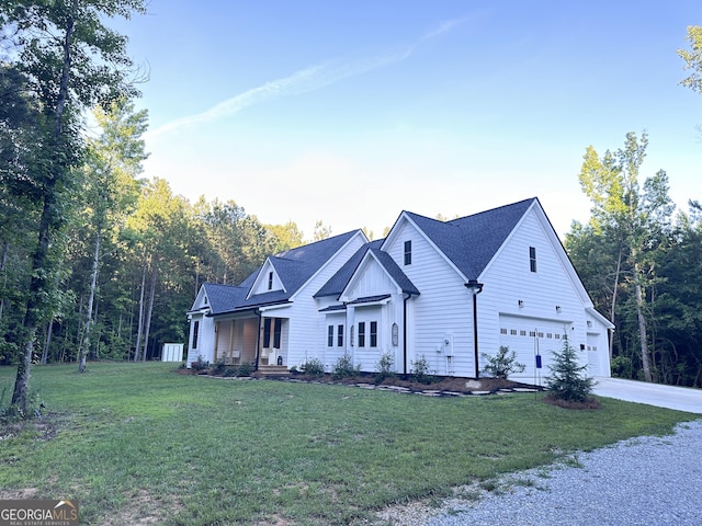 modern farmhouse featuring a front yard and a garage