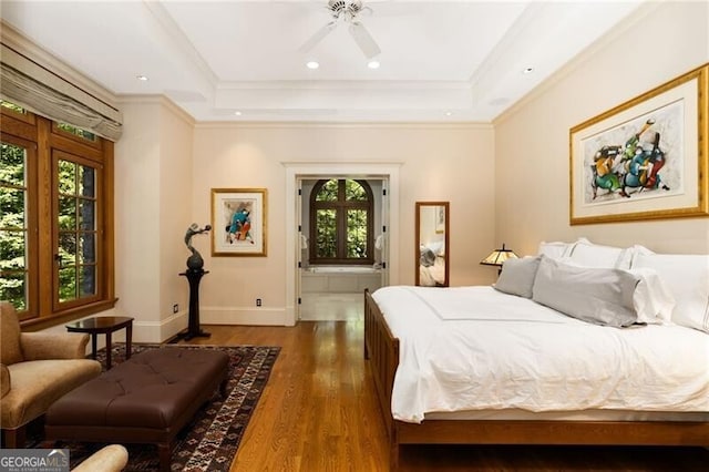 bedroom featuring ensuite bath, a tray ceiling, ceiling fan, crown molding, and dark hardwood / wood-style floors