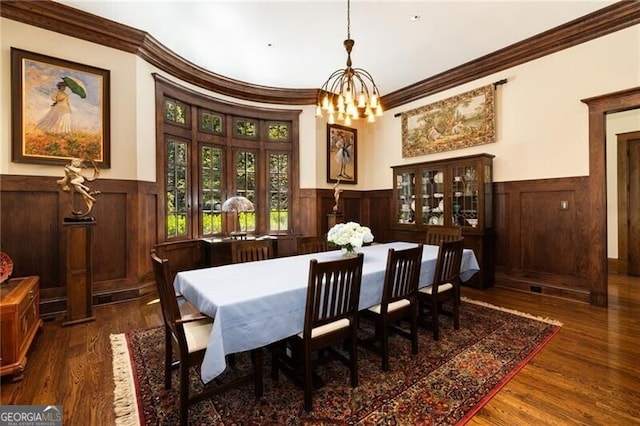 dining room with dark hardwood / wood-style flooring, an inviting chandelier, and crown molding