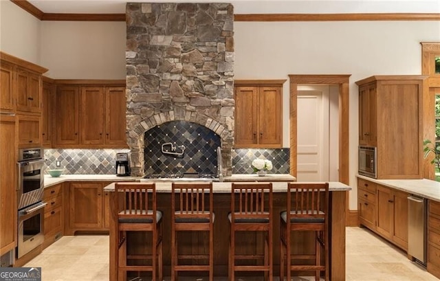 kitchen with a kitchen bar, backsplash, a kitchen island, and appliances with stainless steel finishes