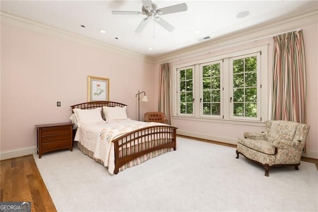 bedroom with ceiling fan, ornamental molding, and hardwood / wood-style flooring