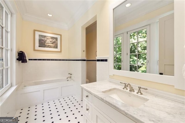 bathroom featuring vanity, crown molding, a bath, tile patterned flooring, and toilet