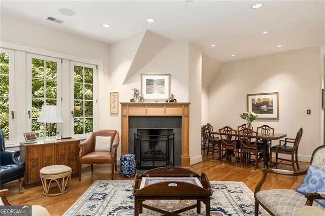 living area with light hardwood / wood-style floors and vaulted ceiling