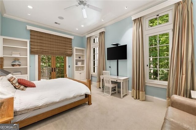 carpeted bedroom with multiple windows, french doors, ceiling fan, and ornamental molding