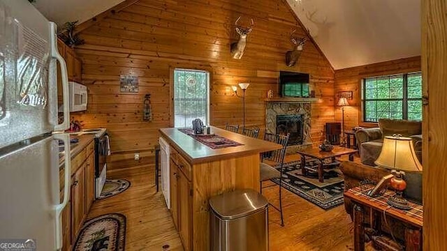 1509 Millenium Dr, Young Harris, GA 30582 - kitchen featuring white appliances, light wood finished floors, vaulted ceiling, a center island, and a fireplace