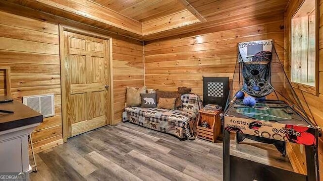 bedroom with hardwood / wood-style flooring, wooden ceiling, and wood walls