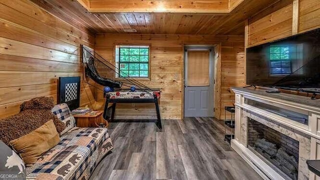 living area featuring wood walls, wood ceiling, and dark hardwood / wood-style flooring