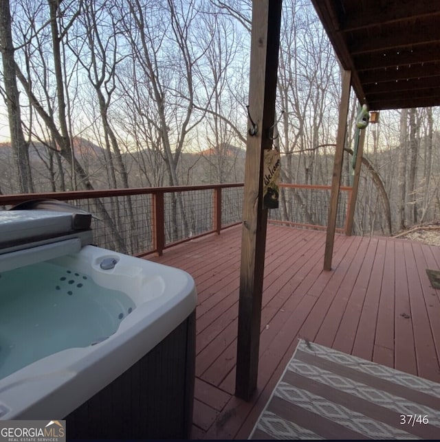 deck at dusk with a hot tub