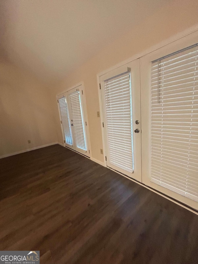 foyer entrance featuring french doors, dark hardwood / wood-style floors, and vaulted ceiling