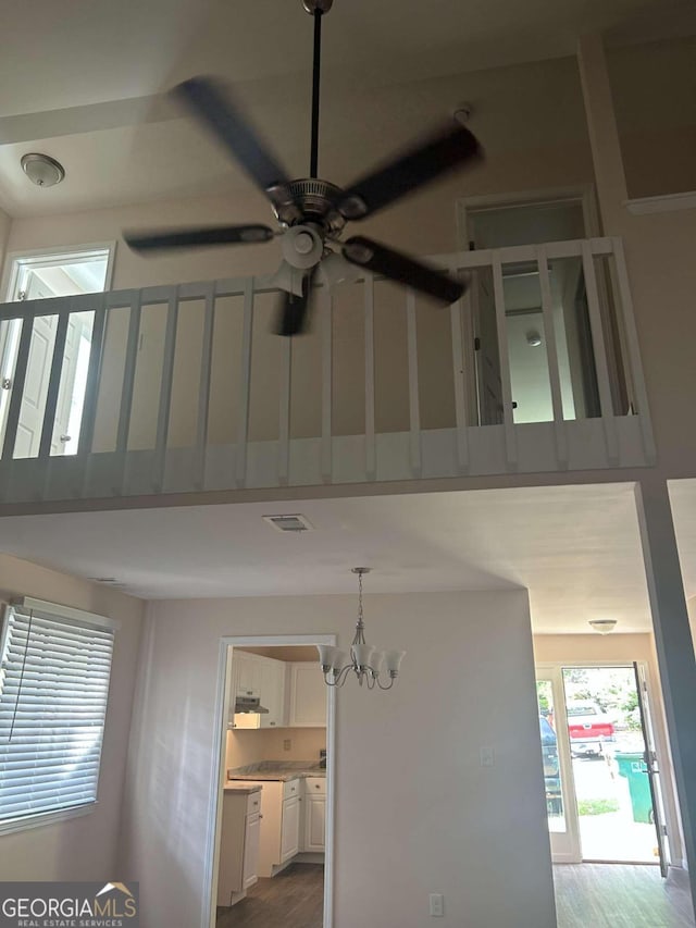 interior details with ceiling fan with notable chandelier