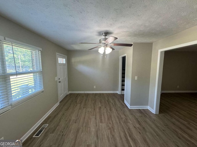 interior space with ceiling fan, dark wood-type flooring, and a textured ceiling