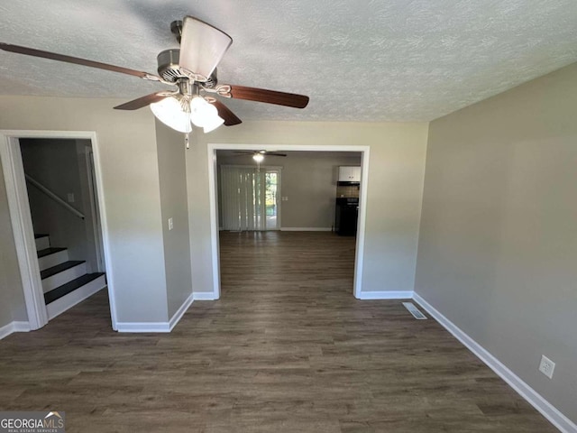 unfurnished room featuring a textured ceiling and dark hardwood / wood-style flooring