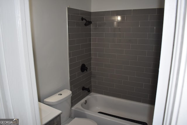 full bathroom with tiled shower / bath, vanity, and toilet