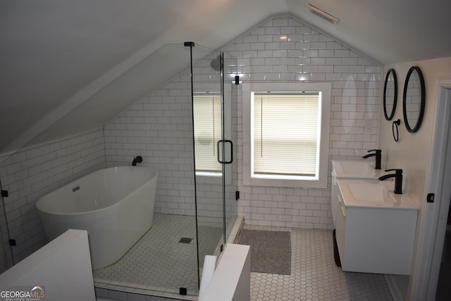 bathroom with tile walls, vanity, vaulted ceiling, tile patterned floors, and shower with separate bathtub