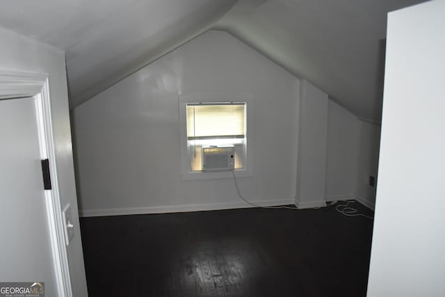 additional living space with cooling unit, vaulted ceiling, and wood-type flooring