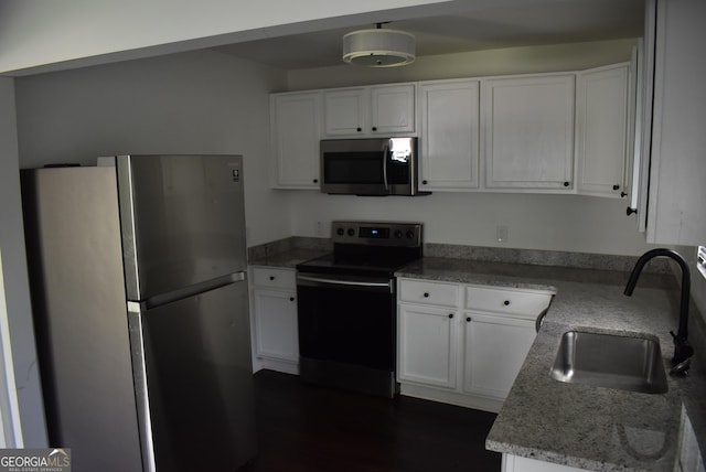 kitchen featuring white cabinetry, sink, light stone countertops, and appliances with stainless steel finishes