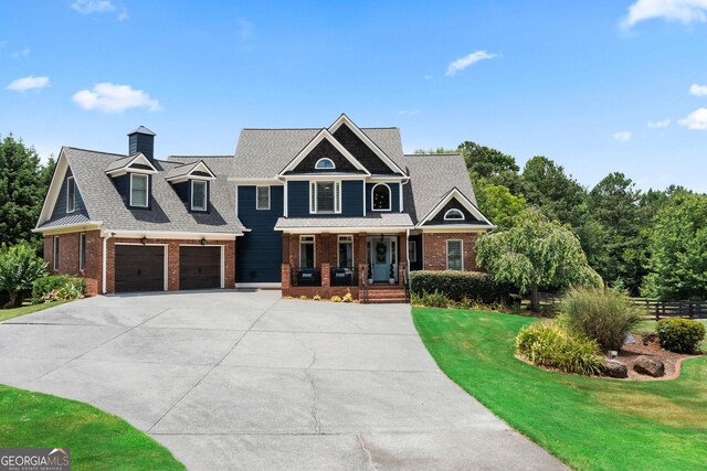 view of front facade with a porch, a garage, and a front yard