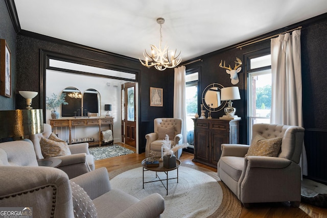 living room with ornamental molding, a healthy amount of sunlight, hardwood / wood-style floors, and a chandelier