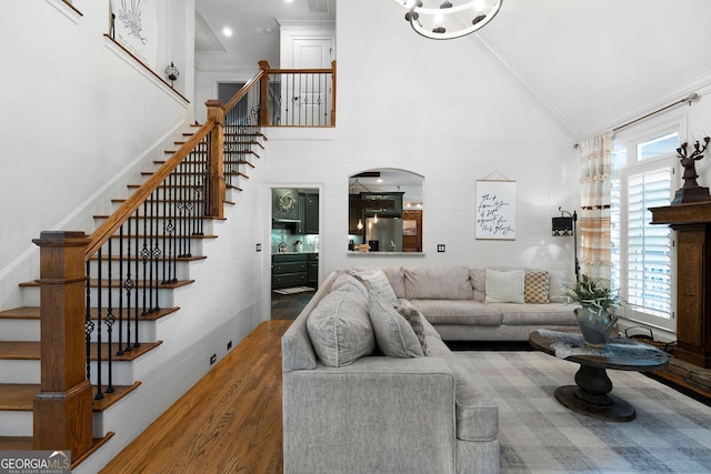 living room with dark hardwood / wood-style flooring, high vaulted ceiling, and ornamental molding