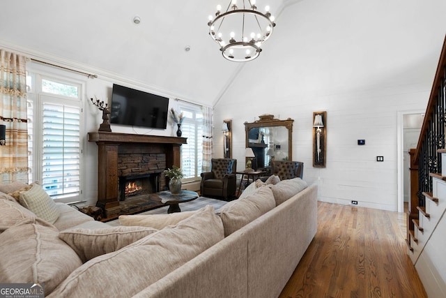 living room with plenty of natural light, a stone fireplace, high vaulted ceiling, and wood-type flooring