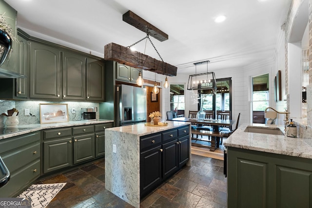 kitchen with hanging light fixtures, a center island, sink, and light stone counters