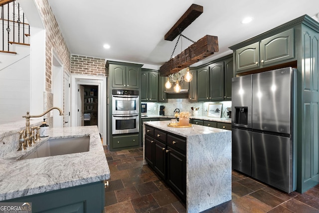 kitchen featuring sink, hanging light fixtures, stainless steel appliances, a kitchen island, and decorative backsplash