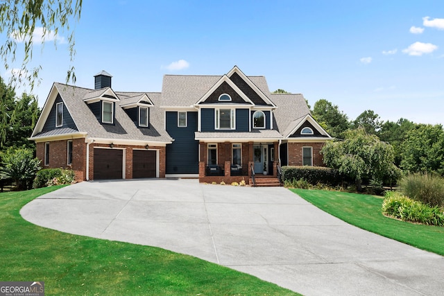 view of front of house with covered porch, a garage, and a front lawn