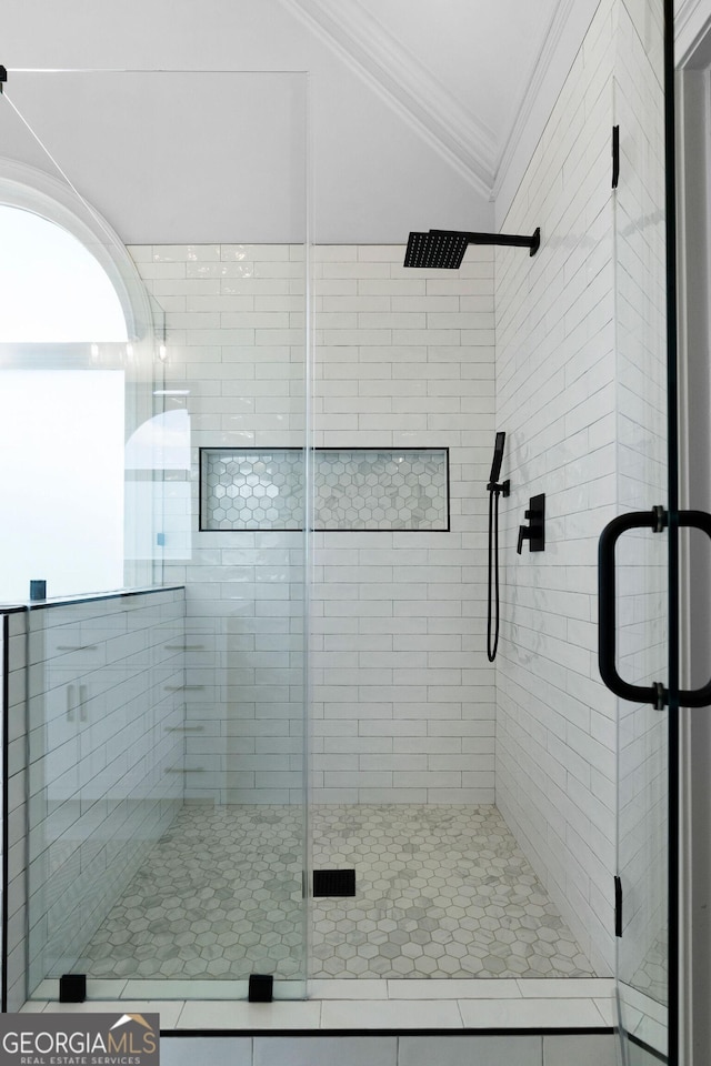 bathroom featuring crown molding, vaulted ceiling, and a shower with door