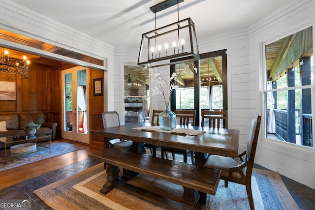 dining area featuring wood walls, dark hardwood / wood-style floors, and a wealth of natural light