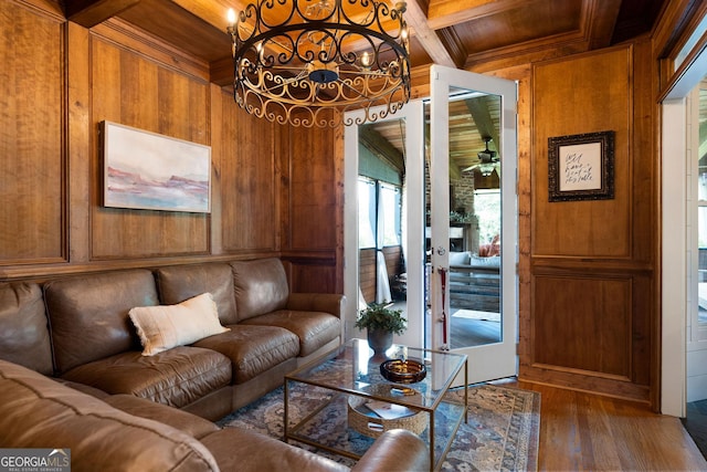 living room featuring dark hardwood / wood-style flooring, coffered ceiling, beam ceiling, and wood walls