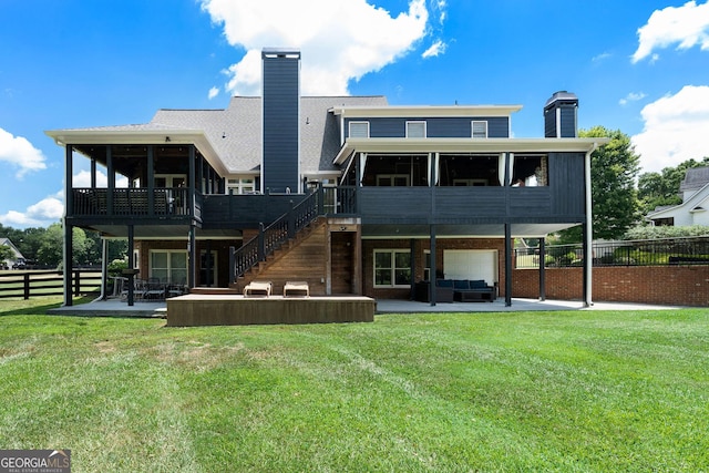 rear view of property with outdoor lounge area, a lawn, a sunroom, and a patio area