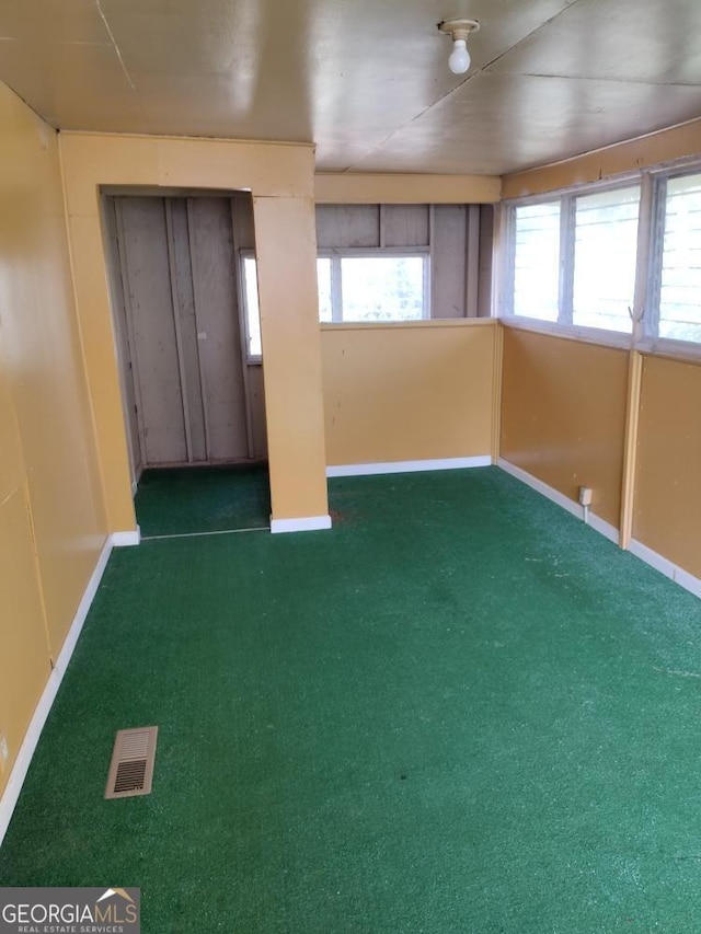 interior space featuring a wealth of natural light and dark colored carpet