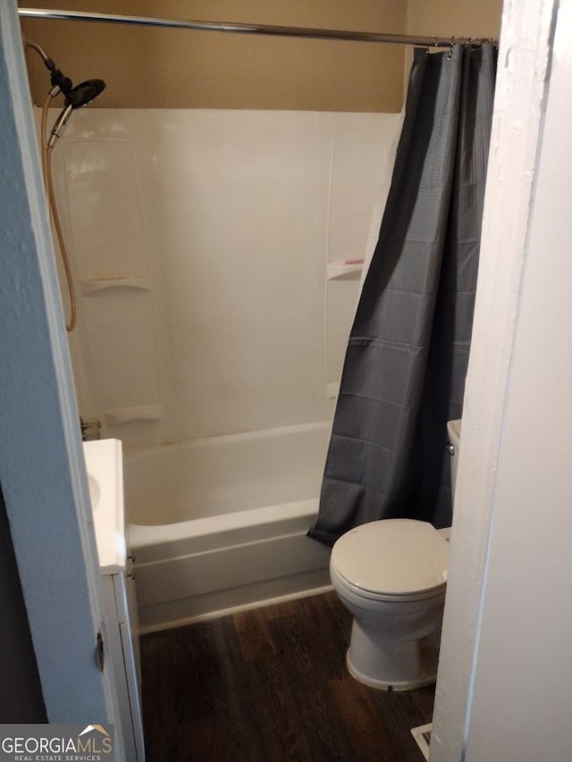 bathroom with hardwood / wood-style floors, toilet, and shower / tub combo