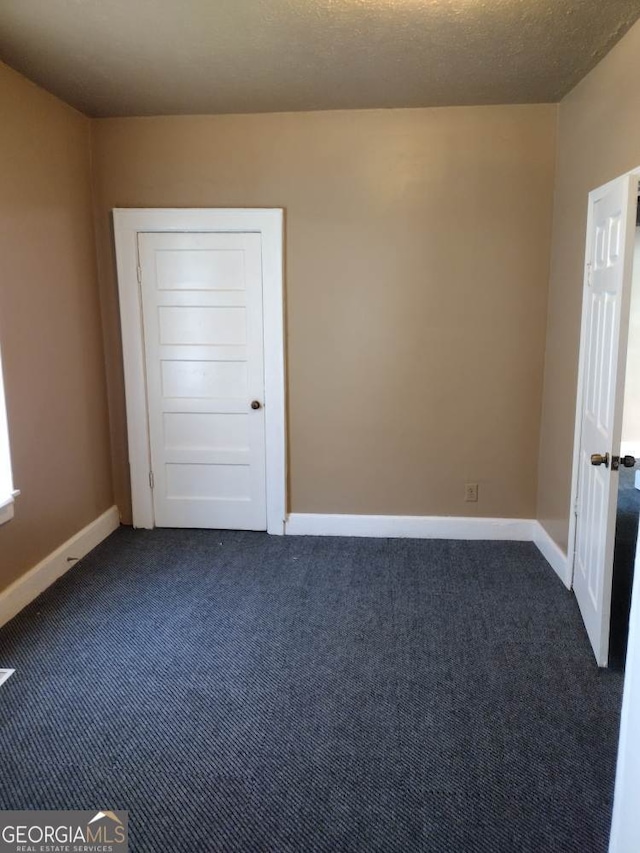 carpeted spare room featuring a textured ceiling