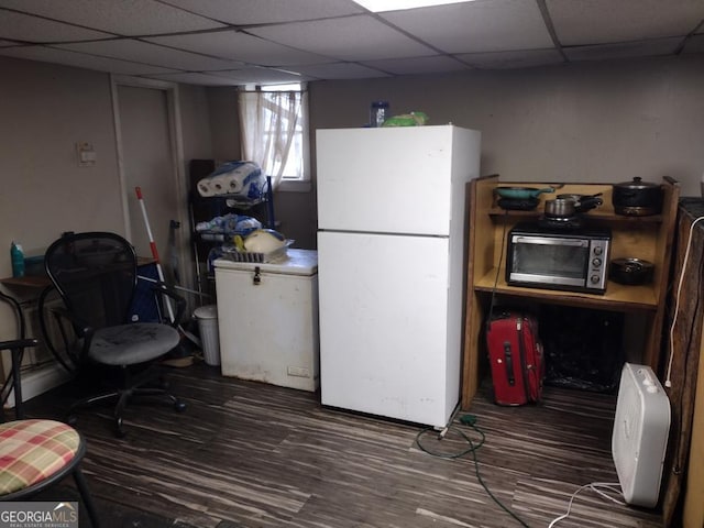 interior space featuring hardwood / wood-style floors, white fridge, and a drop ceiling