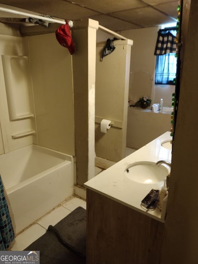 bathroom featuring tile patterned flooring, a drop ceiling, vanity, and shower / tub combo