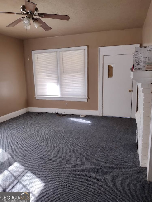 interior space with dark colored carpet and ceiling fan